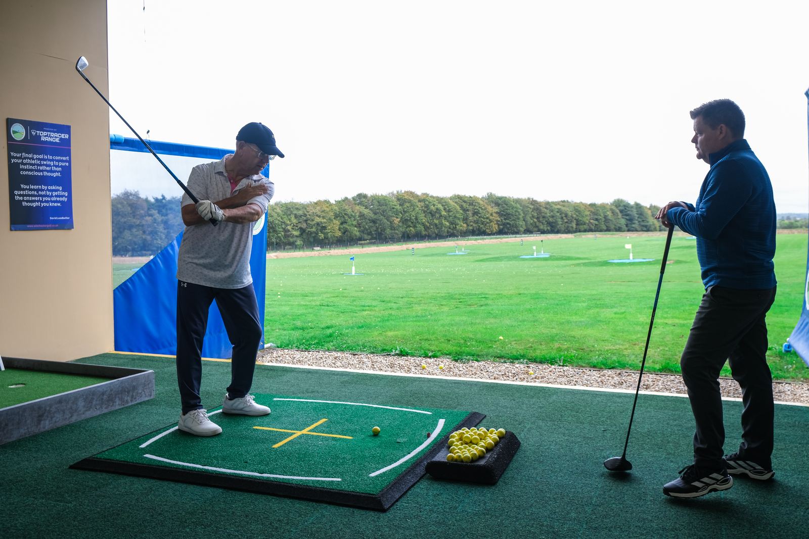 PGA coach watching a student's backswing on the driving range at Winchester Golf Academy