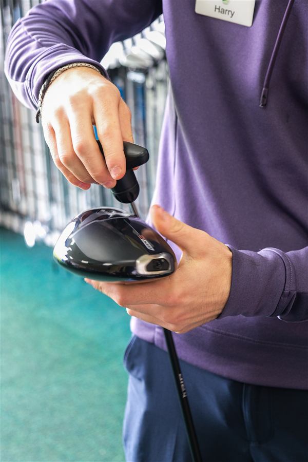 Fitting technician checking a launch monitor sensor on a driver at Winchester Golf Academy